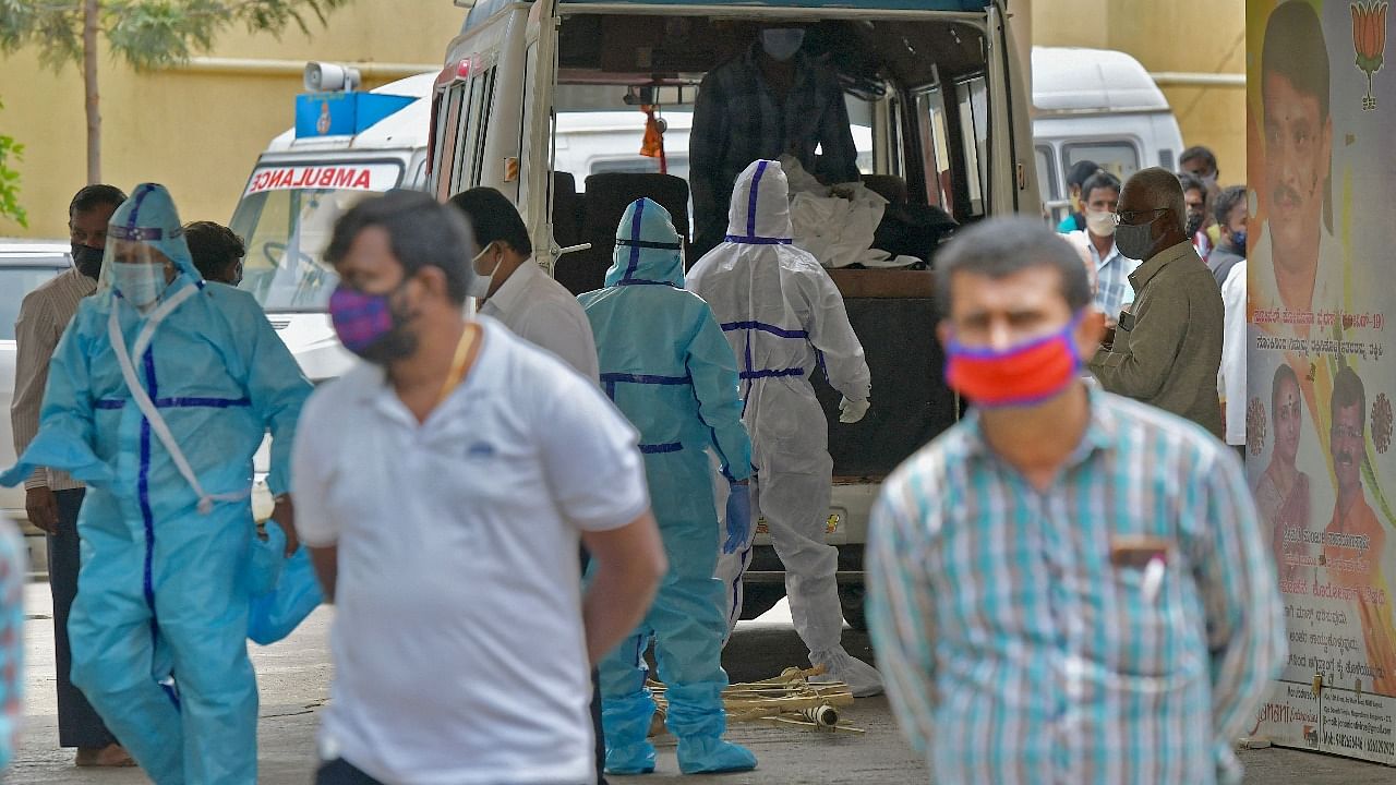 Family members, with help from the municipal staff transfer the bodies of the patients who died of the Covid-19 coronavirus disease from the ambulance at a crematorium in Bengaluru. Credit: AFP photo