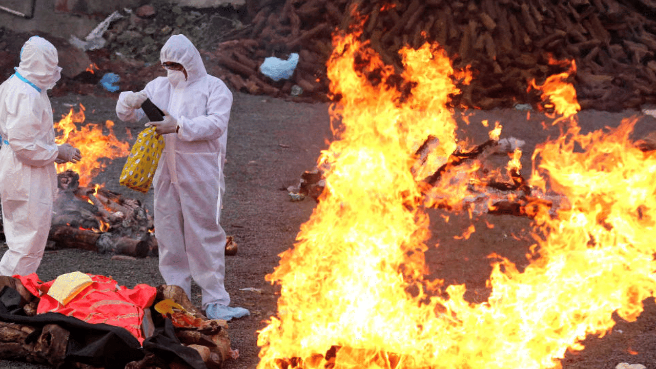  Family members wearing PPE kits, perform cremation of Covid-19 victims, in Bhopal, Thursday, April 15, 2021.  Credit: PTI Photo