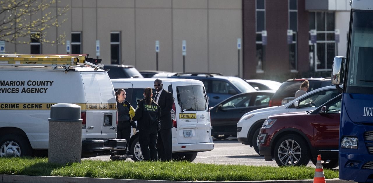 Crime scene investigators gather to speak in the facility's parking lot. Credit: AFP Photo