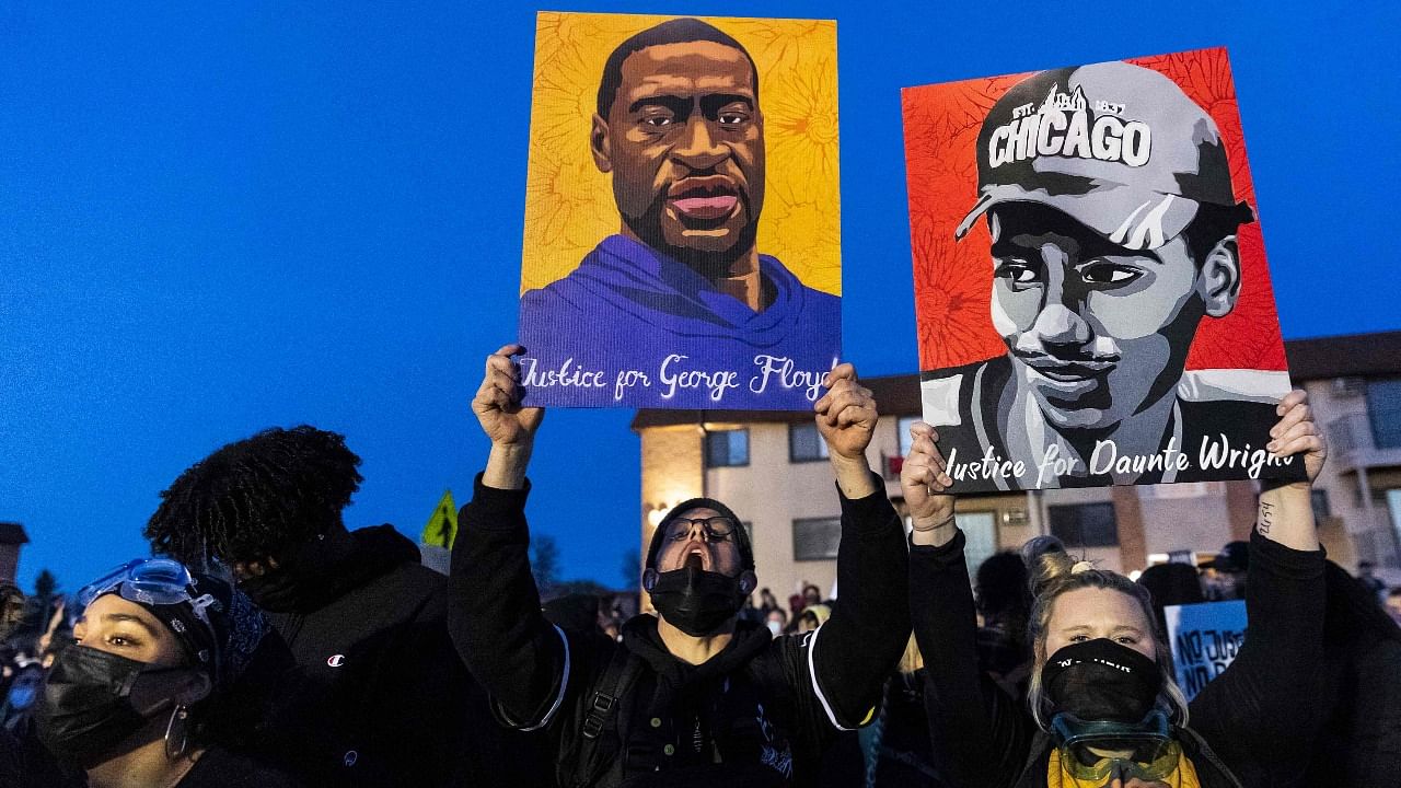 Demonstrators hold George Floyd and Daunte Wright's portraits, both shot and killed by police officers, outside the Brooklyn Center Police Department in Brooklyn Centre, Minnesota on April 16, 2021. Credit: AFP Photo