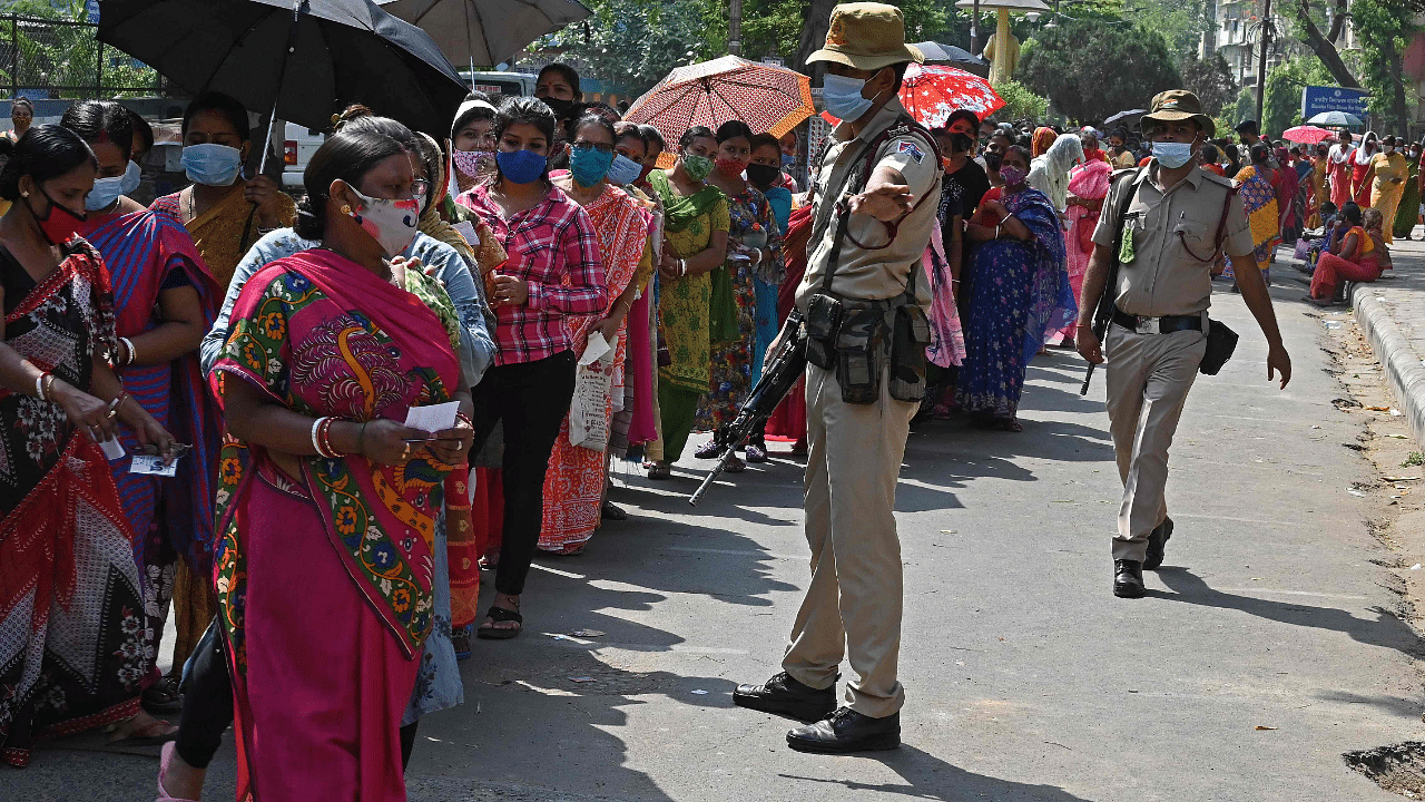 Voters stand in a queue at a polling station to cast their ballot during the 5th phase of West Bengal's state legislative assembly elections in Kolkata. Credit: AFP Photo
