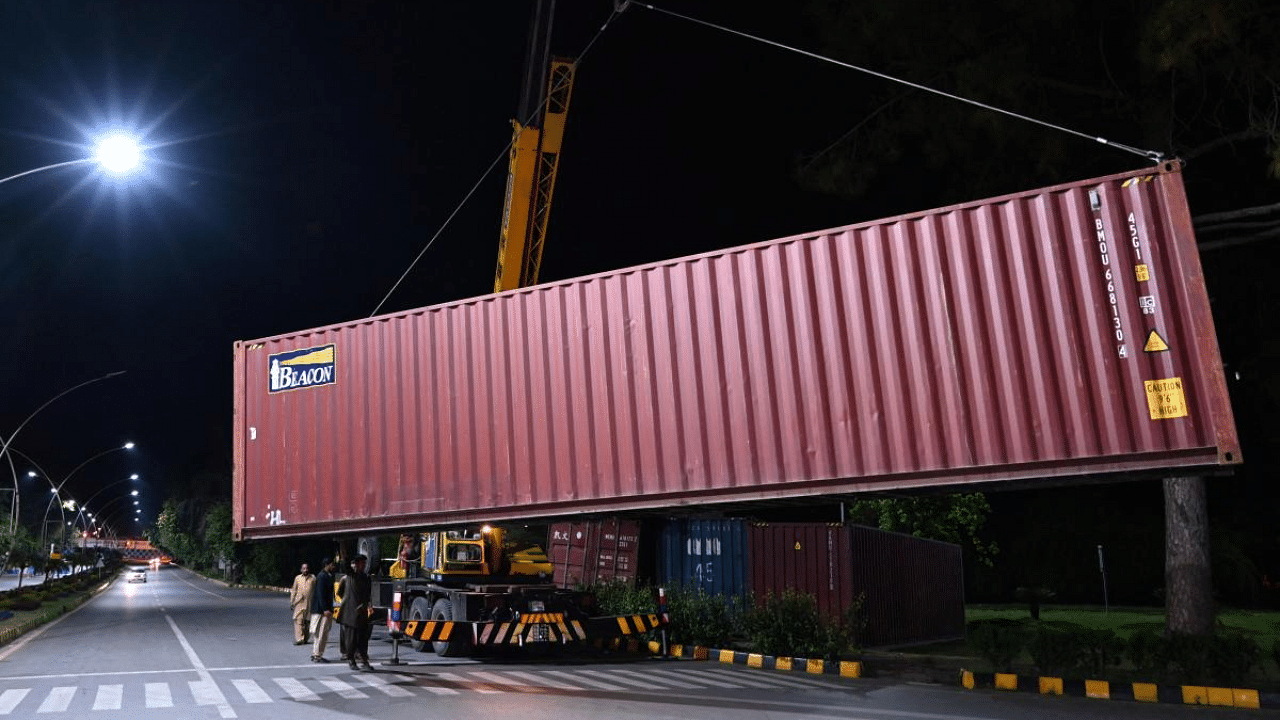 A crane places a shipping container to block a street leading to Red Zone near French Embassy which was secured by the authorities to beef up security following violent anti-France protests, in Islamabad. Credit: AFP photo. 