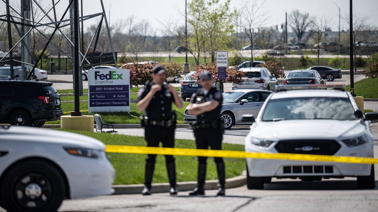 Police officers stand behind caution tape near a crime scene on April 16, 2021 in Indianapolis, Indiana. Credit: AFP photo