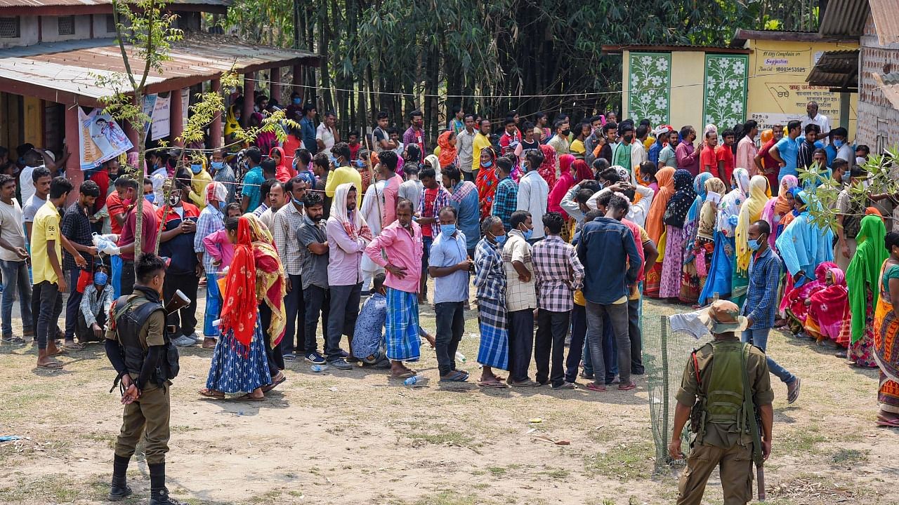 Citizens stand in a queue to cast their votes at a polling station, during the third phase of Assam Assembly elections, in Bajali district. Credit: PTI Photo