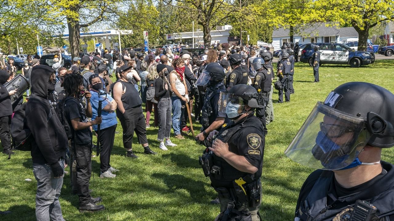 A crowd of protesters surrounds the scene of a police shooting in Lents Park on April 16, 2021 in Portland, Oregon. Credit: AFP Photo