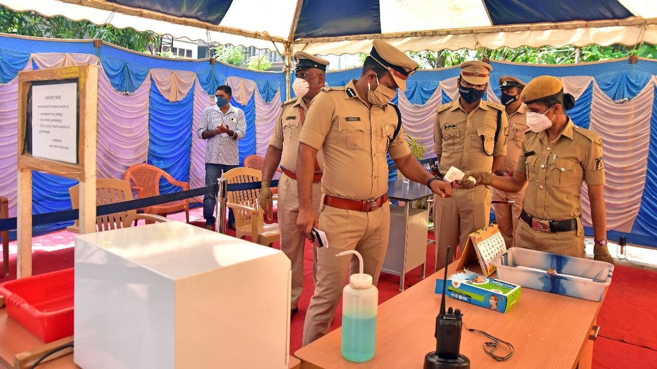 Body temperature of Mangaluru City Police Commissioner N Shashi Kumar being checked at the Urwa Police Station in Mangaluru. Credit: DH Photo