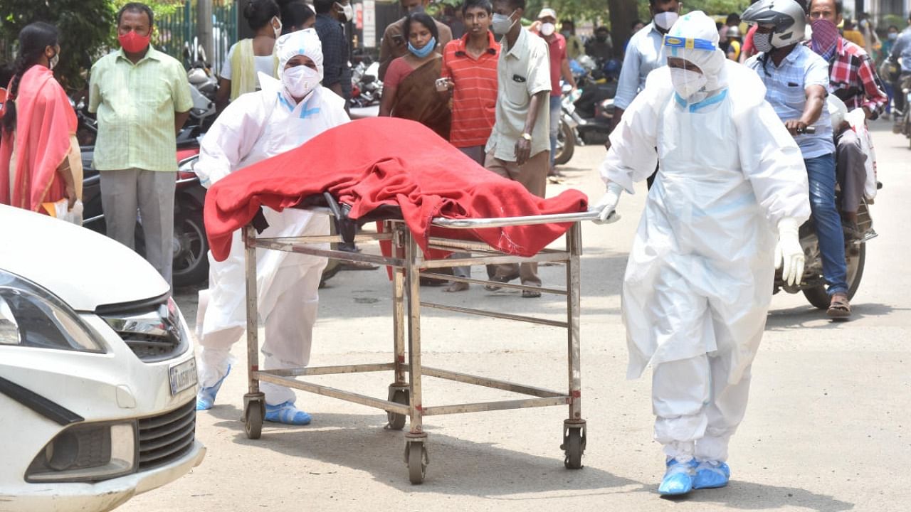 Healthcare workers shift a Covid victim's body from Victoria Hospital to the mortuary in Bengaluru on Saturday, April 17, 2021. Credit: DH PHOTO/JANARDHAN B K