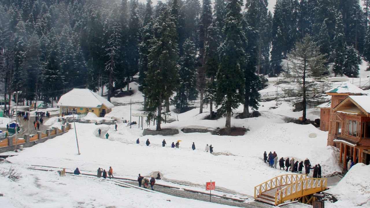 Tourists during fresh snowfall at Gulmarg. Credit: PTI Photo
