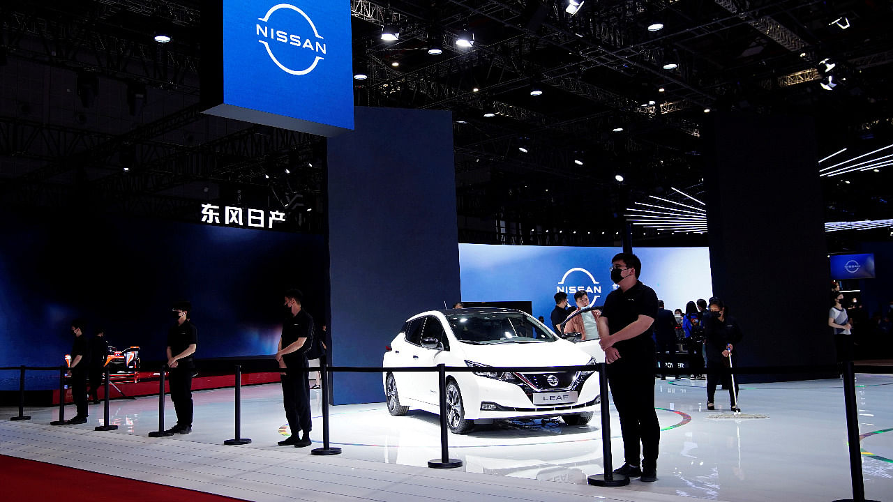 Staff members stand near a Nissan Leaf electric vehicle (EV) displayed at the Nissan booth during a media day for the Auto Shanghai show in Shanghai, China. Credit: Reuters Photo