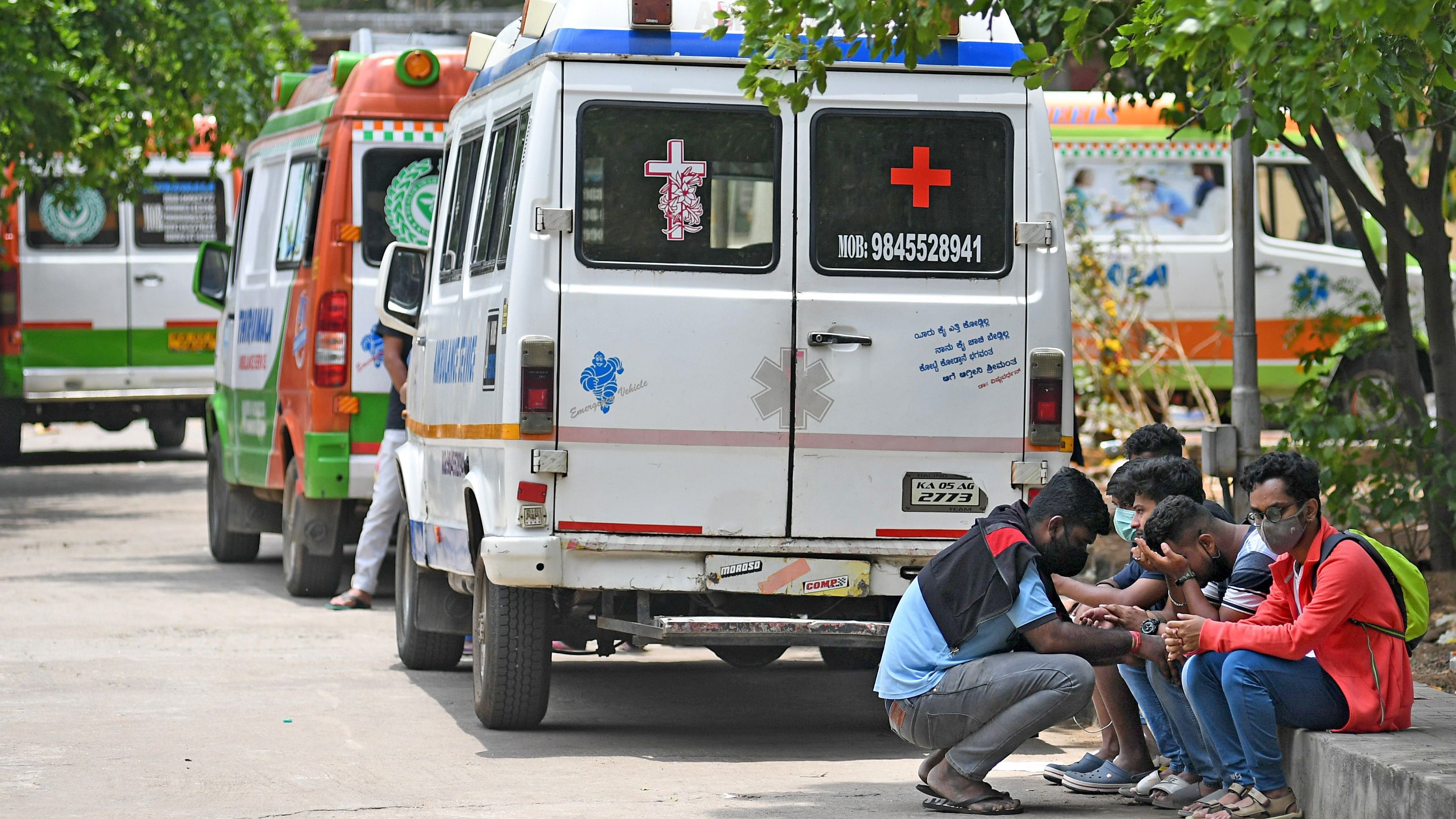 Family and friends grieve the passing of their beloved due to Covid-19 as they wait amid the several ambulances to perform the last rites at Sumanahalli Crematorium in Bengaluru. Credit: DH Photo/ Pushkar V