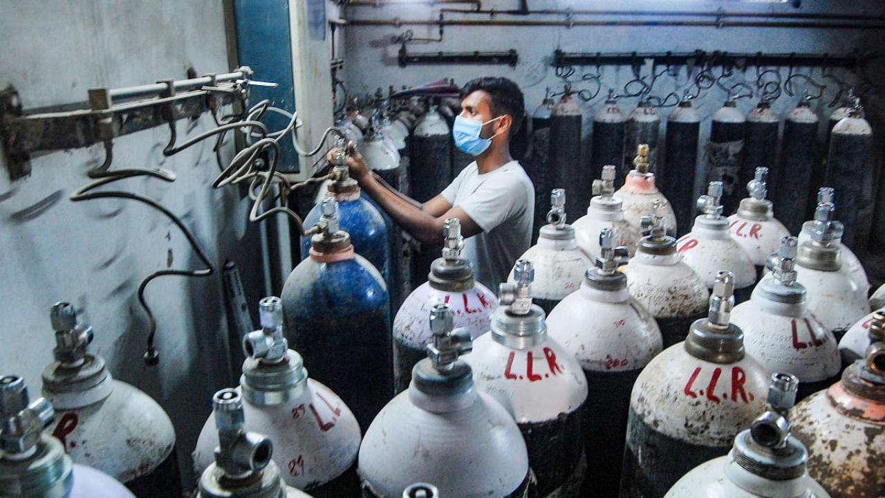 A worker refilling oxygen cylinders at Kanpur LLR Hospital, amid the rise in Covid-19 cases across the Country, in Kanpur. Credit: PTI Photo