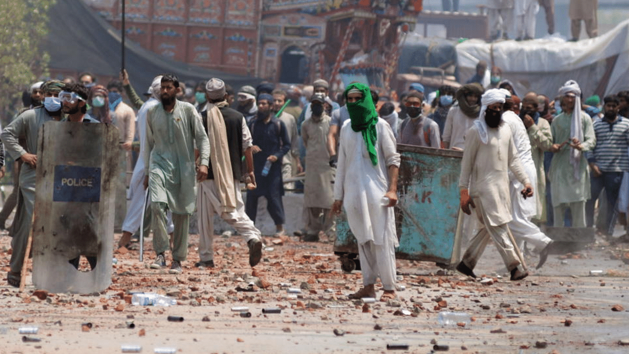 Supporters of the banned Islamist political party Tehrik-e-Labaik Pakistan (TLP) with sticks and stones block a road during a protest in Lahore, Pakistan April 18, 2021. Credit: Reuters Photo
