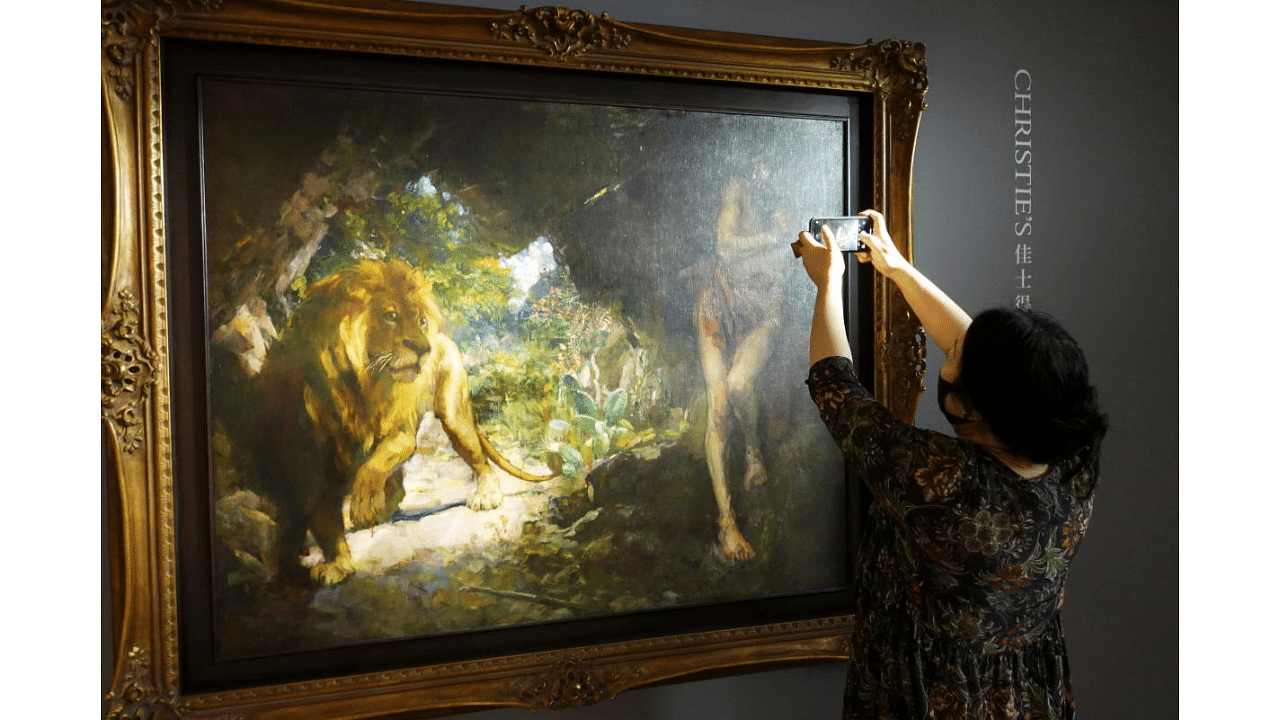A journalist takes pictures of the 1924 painting by Xu Beihong titled "Slave and Lion" during a media event before the item goes on an auction at Christie's, in Hong Kong, China April 19, 2021. Credit: Reuters Photo