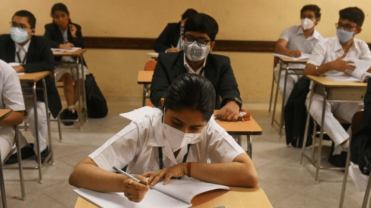 Schools students attend a class at a private school as the schools reopened after almost 11 months of break due to the Covid-19 coronavirus pandemic in Kolkata on February 12, 2021. Credit: AFP Photo