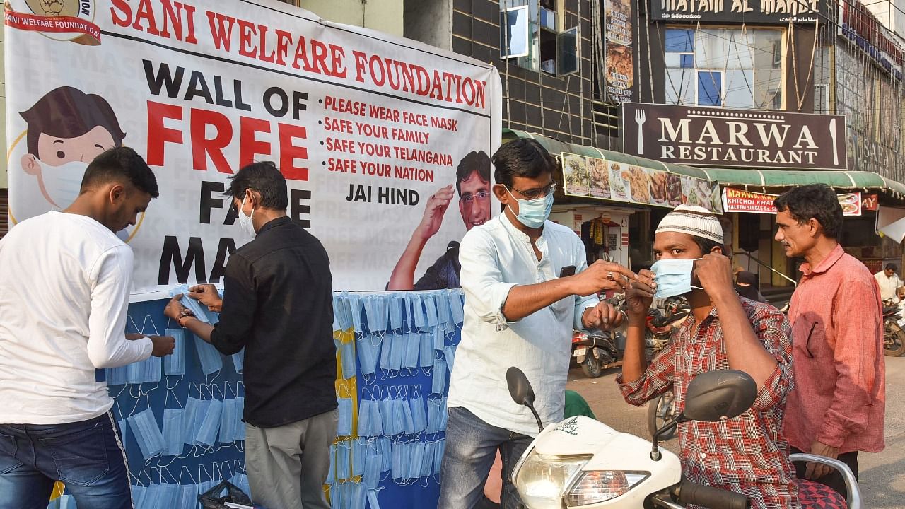 Volunteers distribute masks in view of the recent surge in coronavirus cases, in Hyderabad, Saturday, April 17, 2021. Credit: PTI Photo