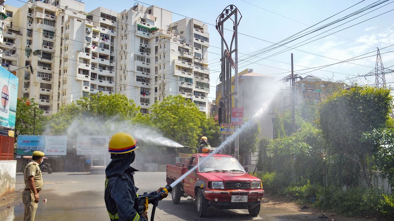 A worker sanitize a locality in Vaishali, as Government imposed Sunday lockdown in states in the wake of rising Covid-19 cases across the country, in Ghaziabad, Sunday, April 18, 2021. Credit: PTI Photo