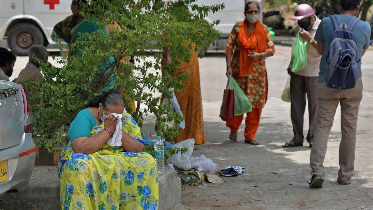 A woman weeps as she with other family members attend the last rites of a deceased who died of the coronavirus disease at a crematorium in Bangalore. Credit: AFP photo. 