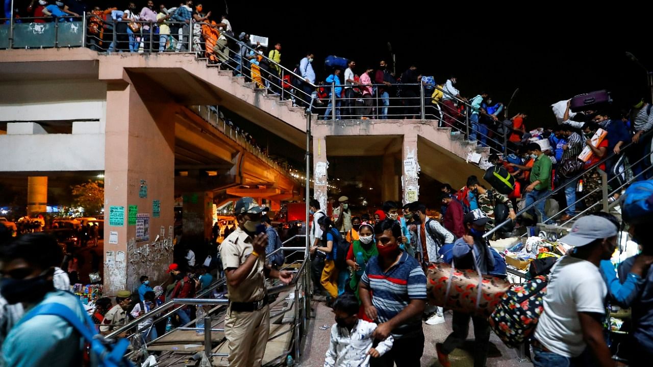 Migrant workers arrive at a bus station to board buses to return to their villages after Delhi government ordered a six-day lockdown to limit the spread of the coronavirus, in Ghaziabad on the outskirts of New Delhi, India, April 19, 2021. Credit: Reuters Photo