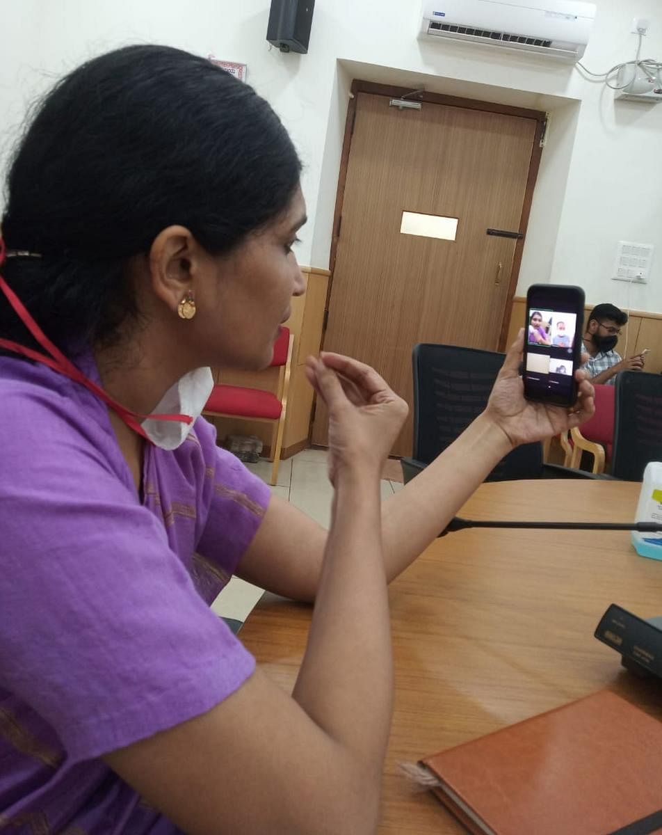 Deputy Commissioner S Aswathi interacts with a Covid patient via a video call in Mandya on Monday. DH Photo