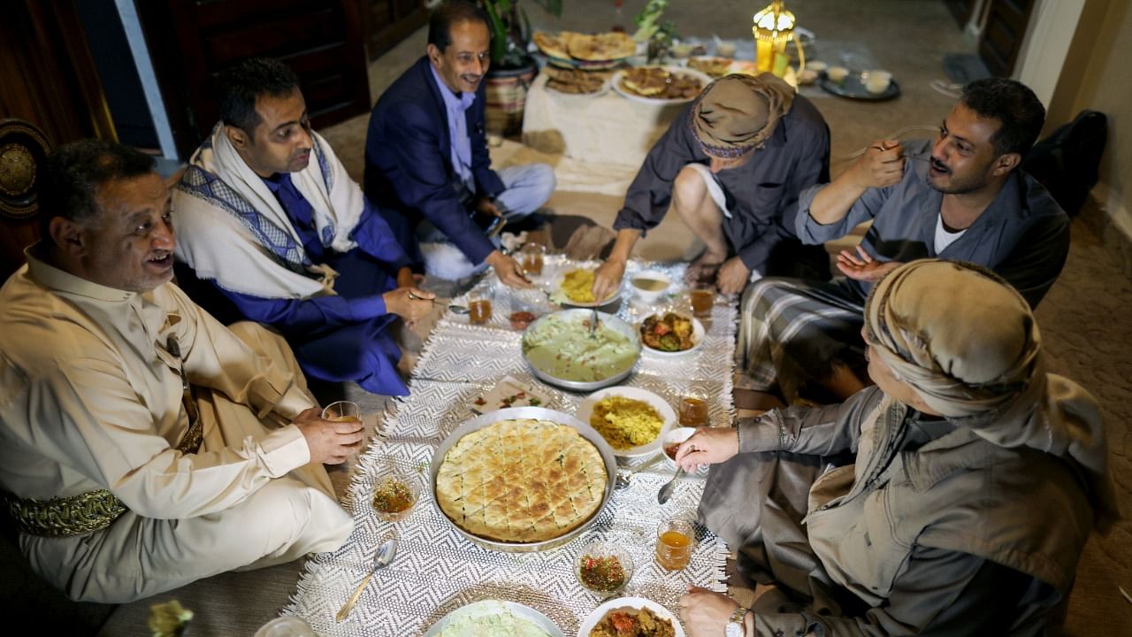 Yemeni singer, Fouad al-Kebsi and his brother Akram, sit with guests for the iftar meal at their family house during the holy month of Ramadan in Sanaa, Yemen April 19, 2021. Credit: Reuters Photo