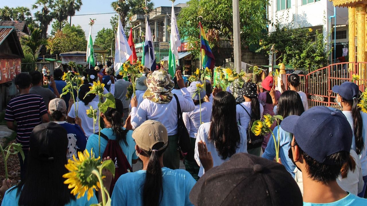 Protesters hold sunflowers during a demonstration against the military coup in Dawei. Credit: AFP Photo/Dawei Watch