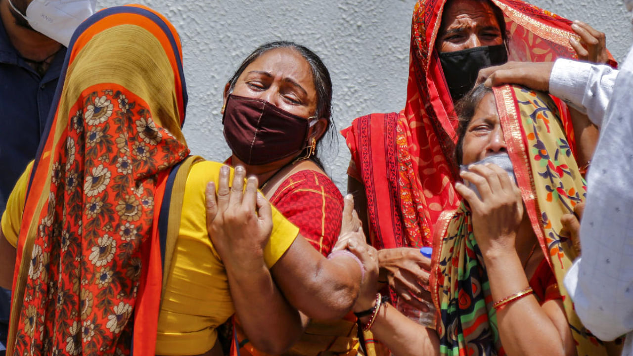 Family members react on the death of a relative, who died of COVID-19, as coronavirus cases surge across the country, outside a mortuary in Ahmedabad. Credit: PTI photo. 