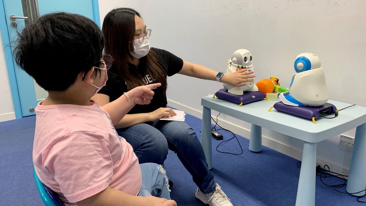 Autism tutor Sarah Ng uses robots to teach a 5-year-old child with special needs to introduce herself, in Hong Kong. Credit: Reuters photo