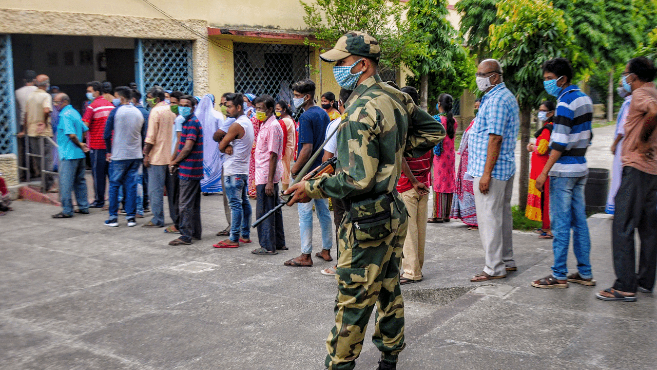 People stand in a queue to cast their votes at a polling station at Krishnagar, in Nadia. Credit: PTI Photo