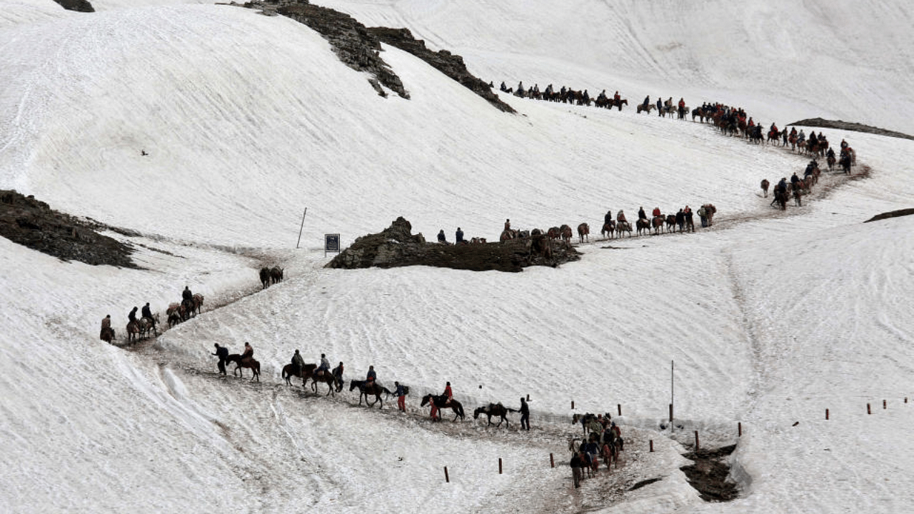 Hindu pilgrims cross a snow-covered mountain to reach the Amarnath cave shrine where they worship an ice stalagmite that Hindus believe to be the symbol of Lord Shiva, at Waval in the Kashmir region, July 6, 2019. Credit: Reuters Photo