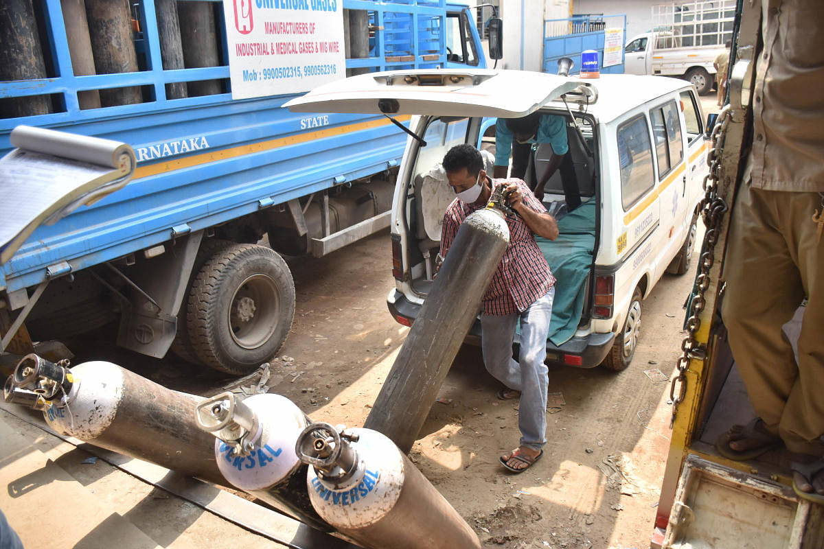 Hospital personnel refilling oxygen cylinders at the Universal Air's refilling station at Peenya in Bengaluru. Credit: DH photo. 
