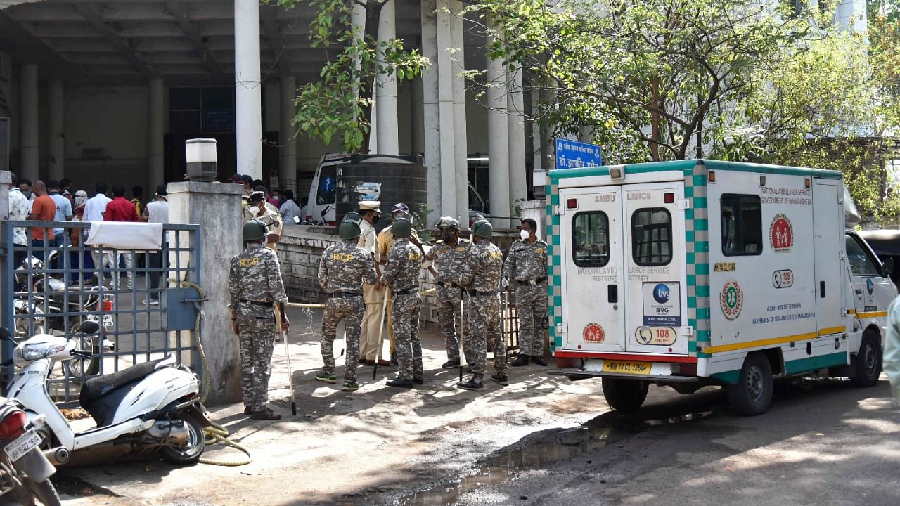Police personnel stand guard at the entrance of the Zakir Hussain Hospital after an oxygen tanker leaked outside the hospital, in Nashik. Credit: AFP photo