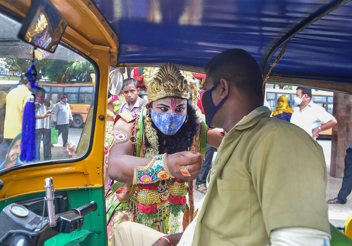 Artists dressed as Lord Ram, Laxman and Hanuman distribute face masks to public during an awareness campaign against the spread of the coronavirus, on the occasion of 'Ram Navami' in Bengaluru. Credit: PTI photo.