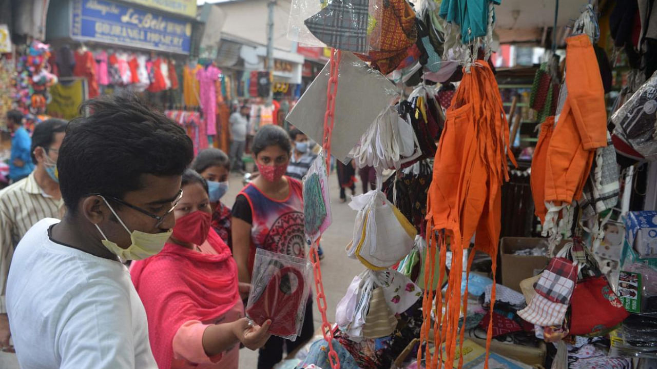 People look at face masks to buy at a roadside stall in Siliguri on April 21, 2021, amid the Covid-19 pandemic. Credit: AFP photo.