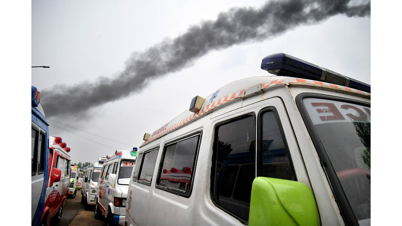 Smoke rises from the Medi Agrahara Crematorium in Bengaluru as ambulances queue up. DH Photo/ Pushkar V