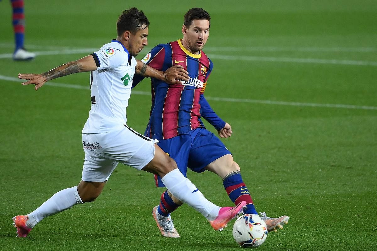  Lionel Messi challenges Getafe's Uruguayan defender Damian Suarez (L) during the Spanish League football match between Barcelona and Getafe at the Camp Nou stadium in Barcelona. Credit: AFP photo.