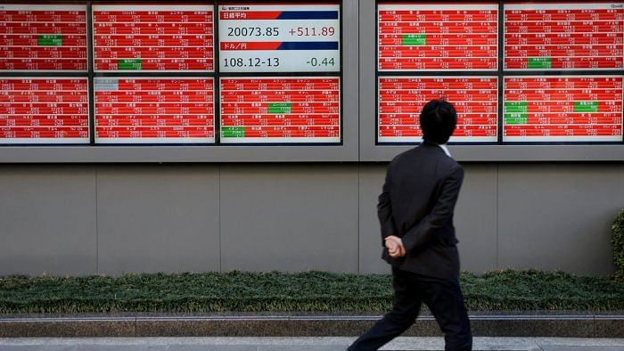 A man looks at an electronic board showing the Nikkei stock index outside a brokerage in Tokyo. Credit: Reuters File Photo
