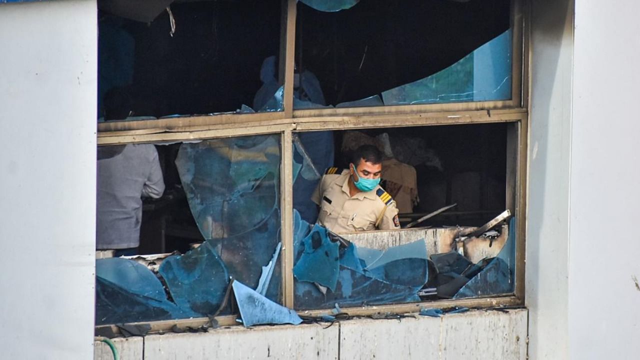 A policeman inspects a burnt-out room at the Vijay Vallabh Hospital in Virar, on the outskirts of Mumbai, on April 23, 2021, after a fire broke out in the ICU of the hospital, killing 13 Covid-19 coronavirus infected patients. Credit: AFP Photo