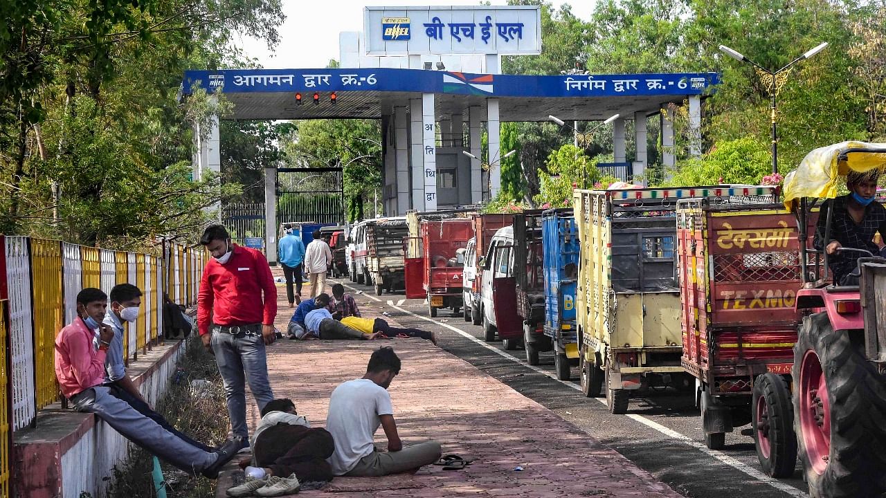 People with their vehicles wait outside BHEL factory to get the oxygen cylinders refilled. Credit: PTI Photo