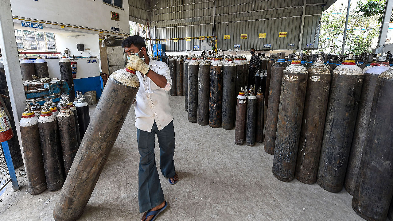 Workers refill cylinders with medical oxygen for supply for Covid-19 patients in Kolkata. Credit: PTI Photo