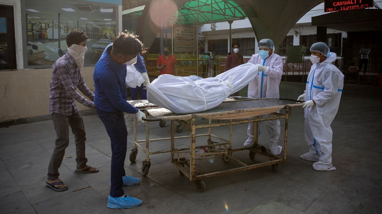 Health workers transfer the body of a victim who was suffering from the coronavirus, from the casualty ward at Guru Teg Bahadur hospital, amidst the spread of the disease in New Delhi, India, April 23, 2021. Credit: Reuters Photo