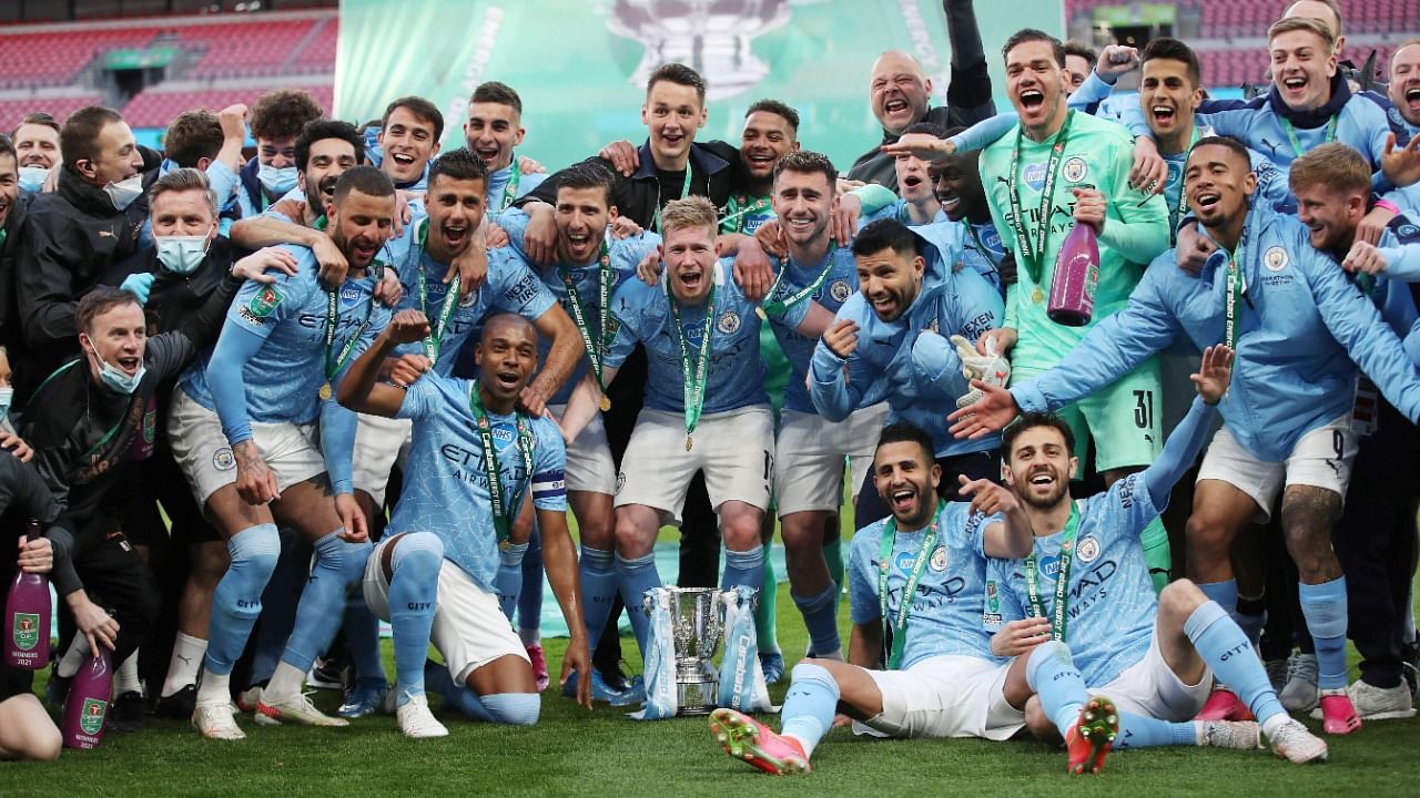 Manchester City players pose with the trophy as they celebrate after winning the Carabao Cup. Credit: Reuters Photo