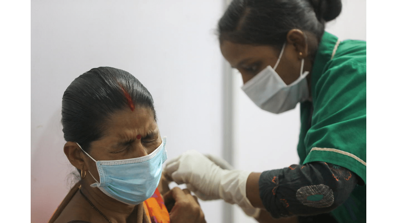 A woman reacts as she receives a dose of COVISHIELD, a coronavirus disease vaccine manufactured by Serum Institute of India, during the start of a four-day "Vaccination Festival" in Mumbai, India, April 11, 2021. Credit: Reuters Photo