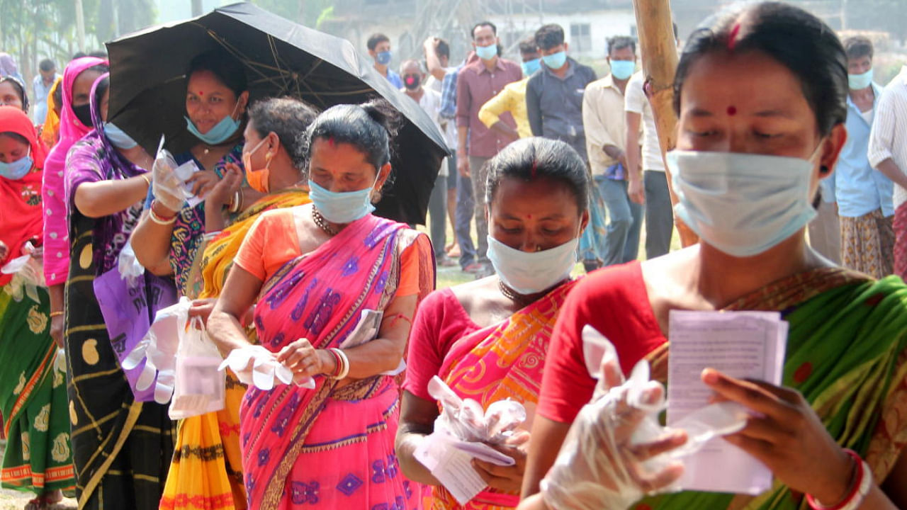  Voters wait in queues to cast votes at a polling station during the 7th phase of West Bengal Assembly elections at a village near Balurghat in South Dinajpur district. Credit: PTI photo.