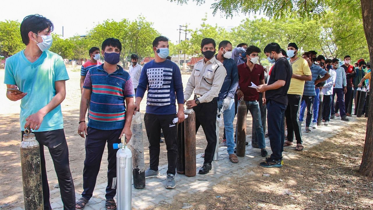 Relatives of Covid-19 patients wait to refill cylinders with medical oxygen, in Gurugram, on Sunday, April 25, 2021. Credit: PTI Photo