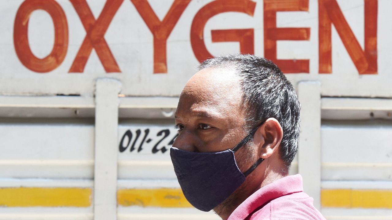 A relative of a Covid-19 patient along with others waits to refill cylinders with medical oxygen at Badarpur during the second wave of coronavirus pandemic in India, in New Delhi, Sunday, April 25, 2021. Credit: PTI Photo