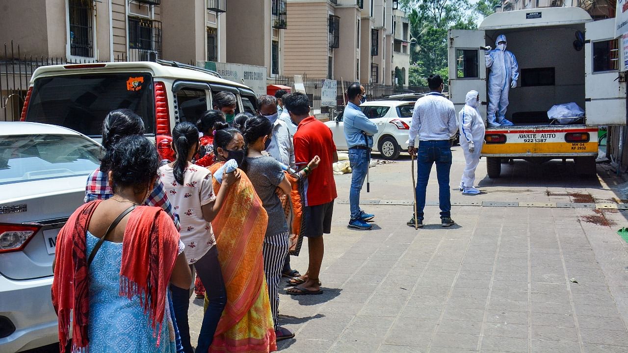 Relatives wait outside Vartak Nagar hospital to collect dead bodies of four Covid-19 patients, in Thane. Credit: PTI photo