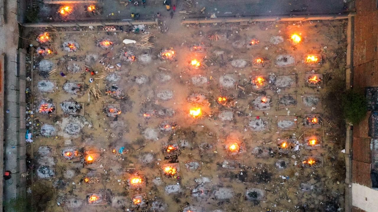 In this aerial picture taken on April 26, 2021, burning pyres of victims who lost their lives due to the Covid-19 coronavirus are seen at a cremation ground in New Delhi. Credit: AFP Photo