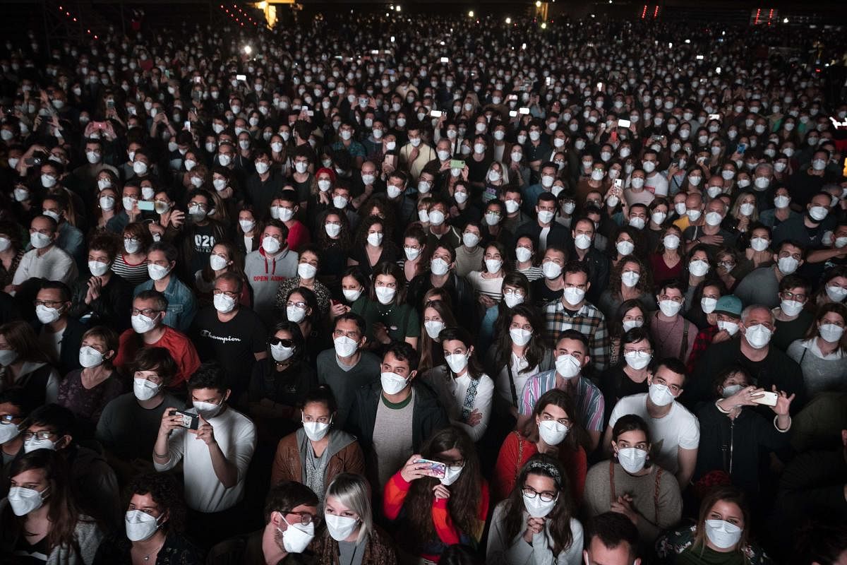 People using face masks attend a music concert in Barcelona, Spain. Credit: AP photo.