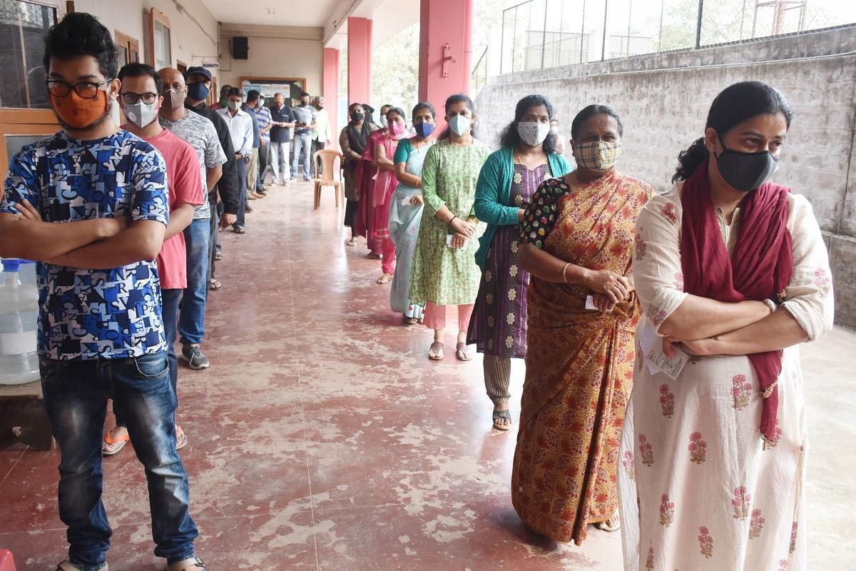 Voters wait in queues following social distancing in Madikeri, to cast their vote.