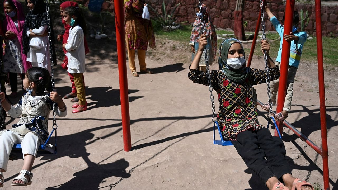 Kashmiri children play in a park near the Line of Control, de facto border between India and Pakistan at Salohi village in Poonch district. Credit: AFP Photo